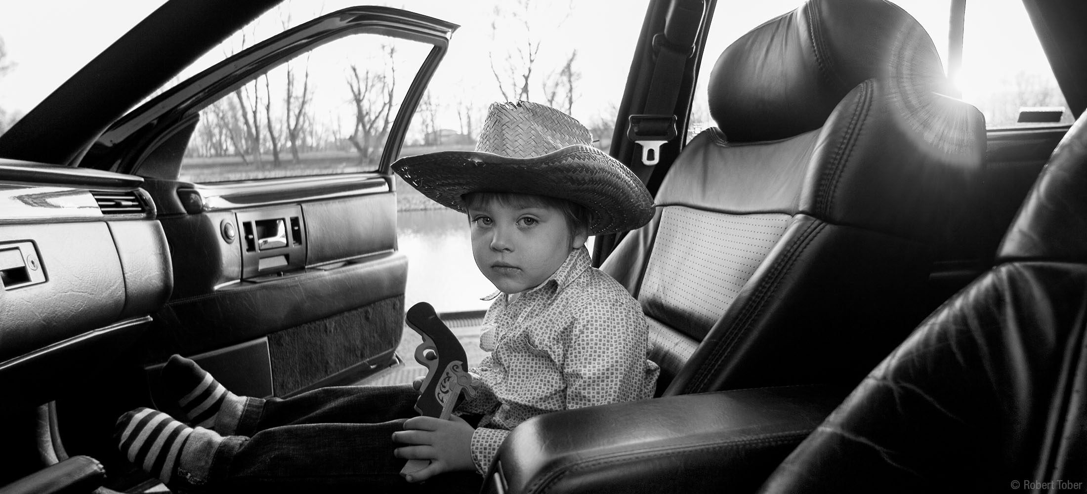 junge-mit-pistole-im-cadillac-sts-kinderfotograf-kleinkind-robert-tober-fotostudio-sterngasse-8